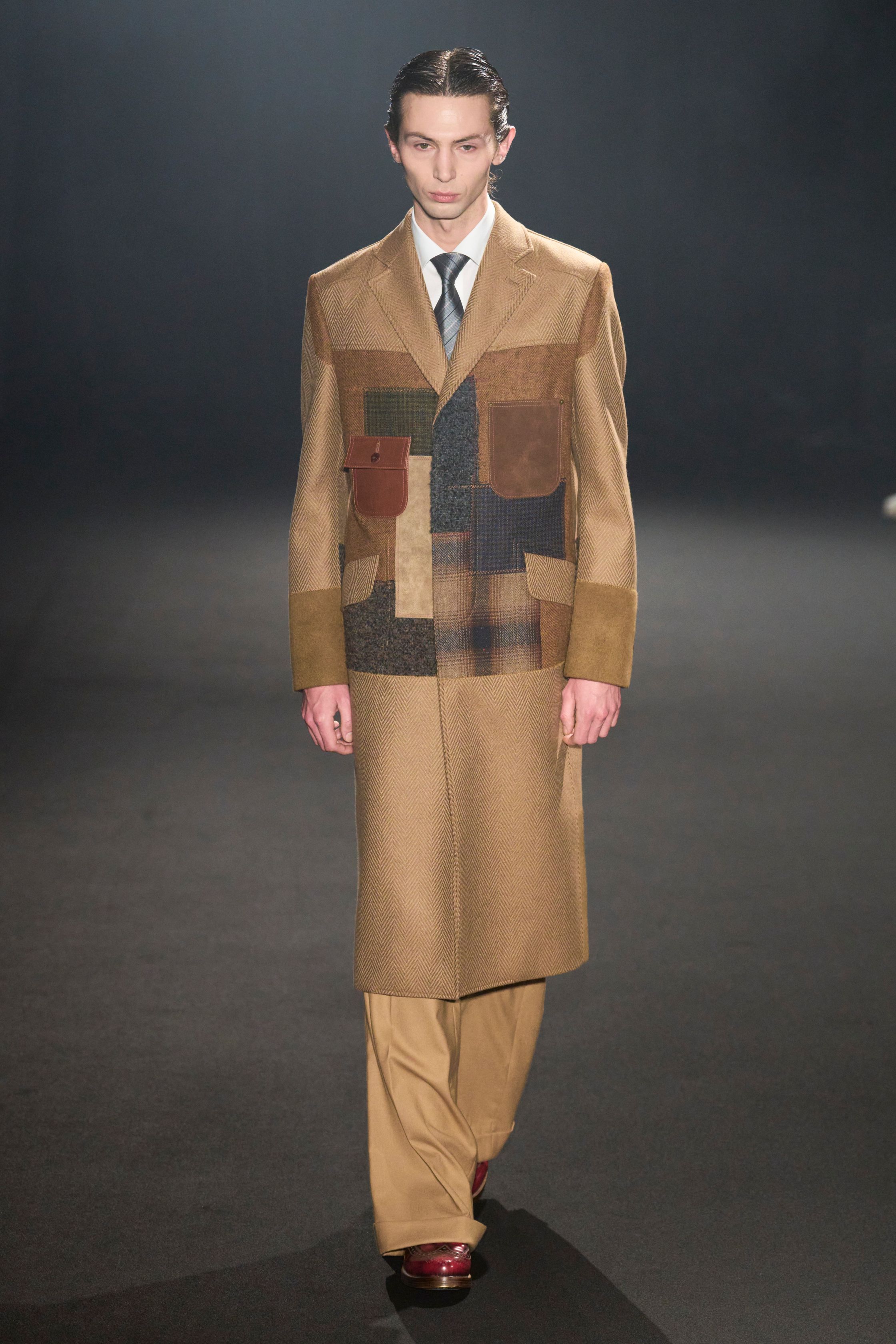 Junya Watanabe 本季以高级拼接与结构实验重塑经典男装：西装、皮革、格纹与工装被解构再组合，形成极具张力的层次秩序。熟悉的正装符号被“错误使用”，制造出不稳定却高度精密的视觉冲突，延续品牌对“功能、秩序与混乱”的长期探索-顽石频道趋势研究